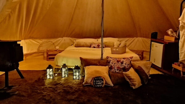 cama queen magic ikigai glamping almohadas candelabros minibar tapete cafe tohallas horno carpa de campaña por dentro